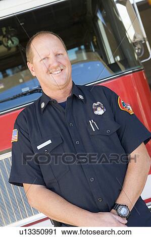 Fireman standing in front of fire engine View Large Photo Image Stock Image - Fireman standing in front of fire engine. Fotosearch