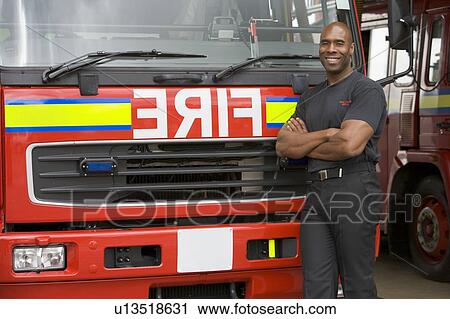 Fireman standing in front of fire engine View Large Photo Image Stock Image - Fireman standing in front of fire engine. Fotosearch