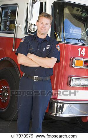 Stock Photo - Fireman standing in front of fire engine. Fotosearch
