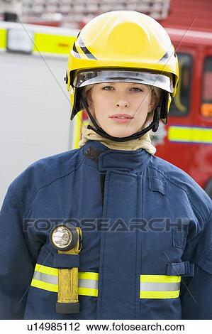 Firewoman standing by fire engine wearing helmet View Large Photo Image Stock Image - Firewoman standing by fire engine wearing helmet. Fotosearch