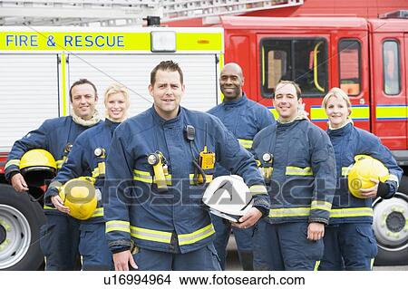 Picture - Six firefighters standing by fire engine. Fotosearch