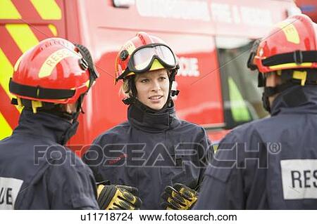 Three rescue workers talking by rescue vehicle View Large Photo Image Picture - Three rescue workers talking by rescue vehicle. Fotosearch