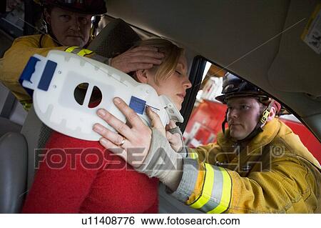 Two firemen helping woman with neck brace View Large Photo Image Stock Photograph - Two firemen helping woman with neck brace. Fotosearch