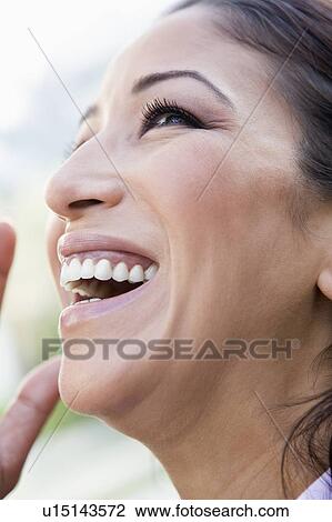 Stock Image - Woman's smiling face outdoors (selective focus). Fotosearch