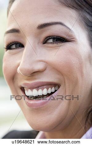 Stock Image - Woman's smiling face outdoors (selective focus). Fotosearch