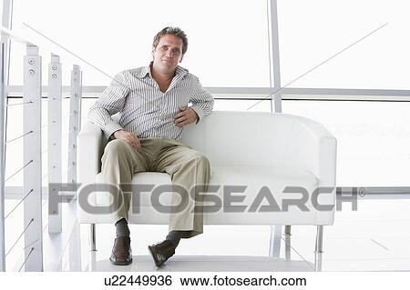 Businessman sitting in office lobby View Large Photo Image Stock Photograph - Businessman sitting in office lobby. Fotosearch