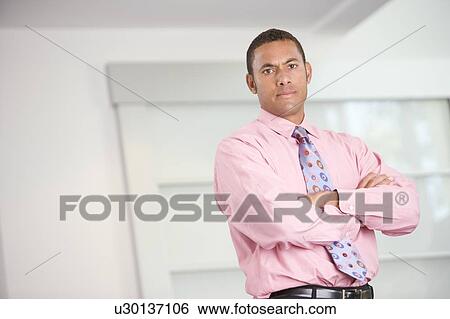 Stock Photograph - Businessman standing indoors. Fotosearch