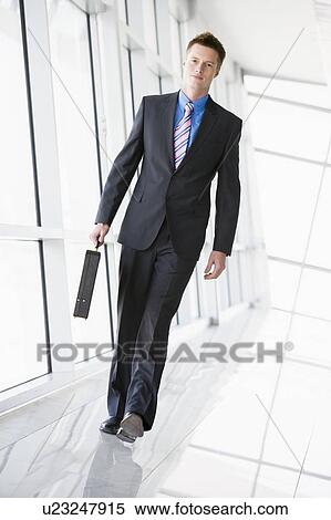 Businessman walking in corridor View Large Photo Image Stock Photography - Businessman walking in corridor. Fotosearch