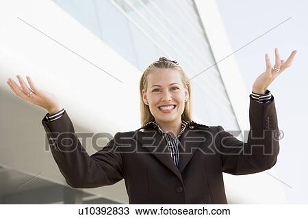 Businesswoman standing outdoors by building smiling with hands out View Large Photo Image Stock Image - Businesswoman standing outdoors by building smiling with hands out. Fotosearch