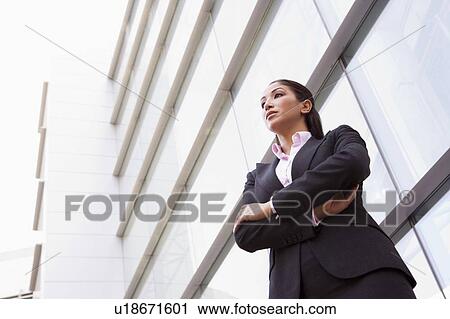 Businesswoman standing outdoors by building (high key/selective focus) View Large Photo Image Stock Image - Businesswoman standing outdoors by building (high key/selective focus). Fotosearch