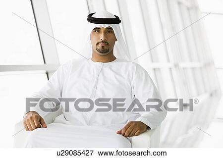 Stock Photo - Man sitting indoors (high key/selective focus). Fotosearch