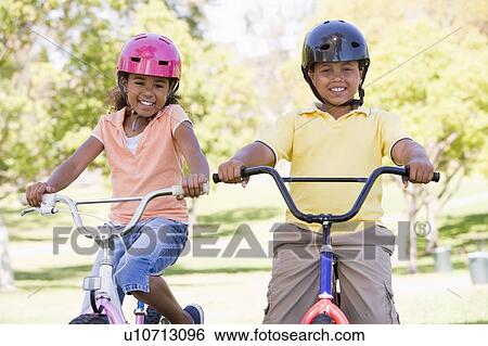Brother and sister outdoors on bicycles smiling View Large Photo Image Stock Photograph - Brother and sister outdoors on bicycles smiling. Fotosearch