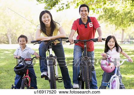 Family on bikes outdoors smiling View Large Photo Image Stock Image - Family on bikes outdoors smiling. Fotosearch