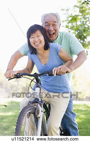 Picture - Mature couple bike riding.. Fotosearch