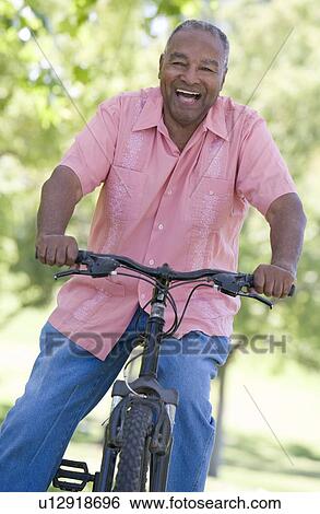Senior man on a bicycle View Large Photo Image Stock Photograph - Senior man on a bicycle. Fotosearch