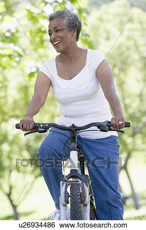 Senior woman on a bicycle View Large Photo Image Stock Photograph - Senior woman on a bicycle. Fotosearch