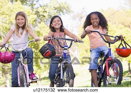Three young girl friends outdoors on bicycles smiling View Large Photo Image Stock Image - Three young girl friends outdoors on bicycles smiling. Fotosearch