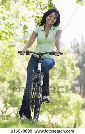 Woman on bicycle smiling View Large Photo Image Stock Photo - Woman on bicycle smiling. Fotosearch