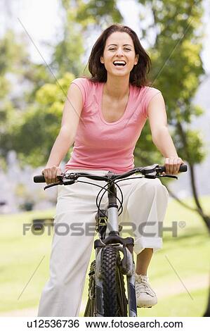 Woman on bicycle smiling View Large Photo Image Stock Photograph - Woman on bicycle smiling. Fotosearch
