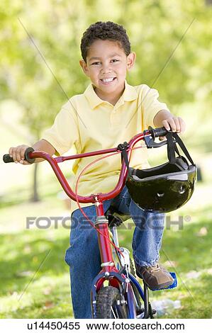 Young boy on bicycle outdoors smiling View Large Photo Image Stock Photography - Young boy on bicycle outdoors smiling. Fotosearch