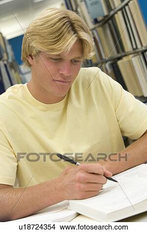 Picture - Man sitting in library studying. Fotosearch