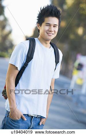 Stock Photo - Man standing outdoors smiling (selective focus). Fotosearch