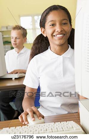 Student at computer terminal with student in background (selective focus) View Large Photo Image Stock Photograph - Student at computer terminal with student in background (selective focus). Fotosearch
