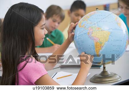 Student in class pointing at a globe (selective focus) View Large Photo Image Stock Photo - Student in class pointing at a globe (selective focus). Fotosearch