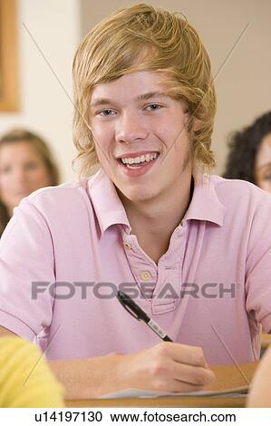 Stock Image - Student in class taking notes (selective focus). Fotosearch