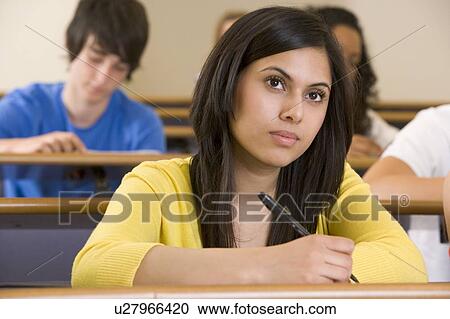 Stock Image - Student in class taking notes (selective focus). Fotosearch