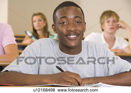 Stock Photo - Student in class taking notes (selective focus). Fotosearch