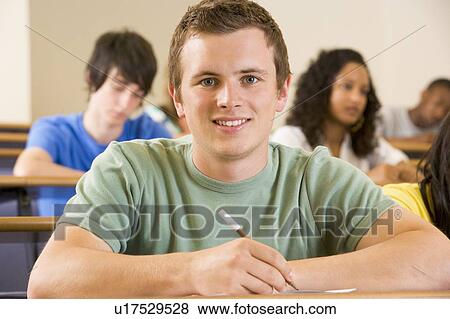 Stock Photo - Student in class taking notes (selective focus). Fotosearch
