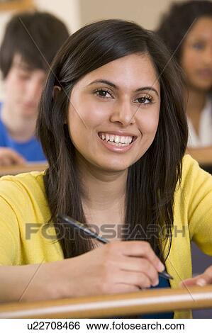 Stock Photograph - Student in class taking notes (selective focus). Fotosearch