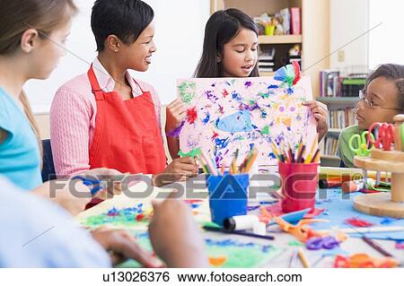 Student showing teacher and classmates her artwork (selective focus) View Large Photo Image Stock Photograph - Student showing teacher and classmates her artwork (selective focus). Fotosearch