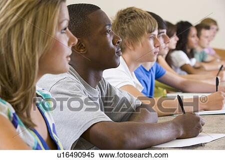 Stock Photography - Students in class paying attention and taking notes (selective focus). Fotosearch