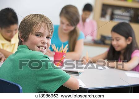 Students in class writing with teacher in background (selective focus) View Large Photo Image Stock Image - Students in class writing with teacher in background (selective focus). Fotosearch