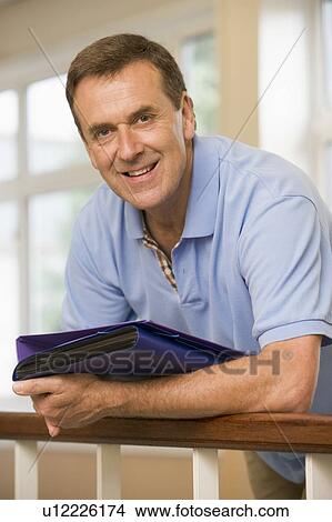Teacher in corridor leaning on railing View Large Photo Image Picture - Teacher in corridor leaning on railing. Fotosearch