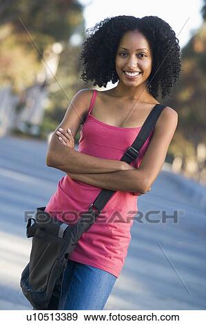Stock Photo - Women standing outdoors smiling (selective focus). Fotosearch