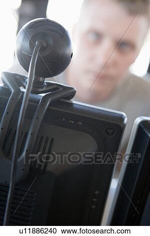 Shot of a man behind a computer and web camera View Large Photo Image Stock Image - Shot of a man behind a computer and web camera. Fotosearch