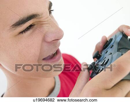 Teenage boy using videogame controller View Large Photo Image Stock Image - Teenage boy using videogame controller. Fotosearch