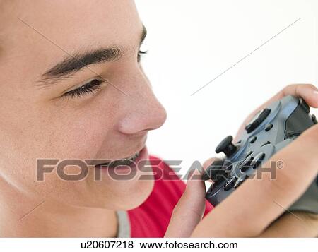 Stock Photo - Teenage boy using videogame controller. Fotosearch