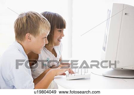Two young children in home office with computer smiling View Large Photo Image Stock Photo - Two young children in home office with computer smiling. Fotosearch