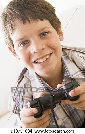 Picture - Young boy holding video game controller smiling. Fotosearch