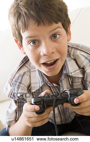 Young boy holding video game controller View Large Photo Image Stock Image - Young boy holding video game controller. Fotosearch