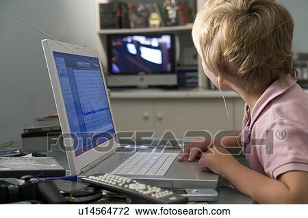 Young boy in bedroom using laptop and listening to MP3 player View Large Photo Image Stock Image - Young boy in bedroom using laptop and listening to MP3 player. Fotosearch