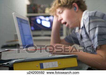 Young boy in bedroom yawning using laptop and listening to MP3 player View Large Photo Image Stock Image - Young boy in bedroom yawning using laptop and listening to MP3 player. Fotosearch