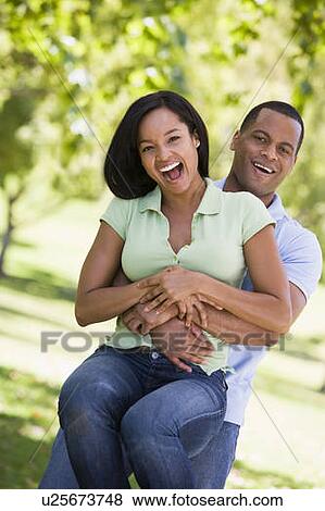 Stock Photo - Couple being playful outdoors smiling. Fotosearch
