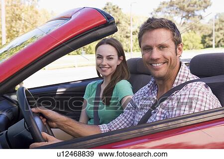 Stock Photo - Couple in convertible car smiling. Fotosearch