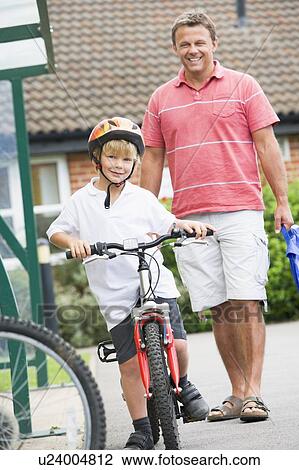 Stock Image - Father and Son outside school with bicycle. Fotosearch