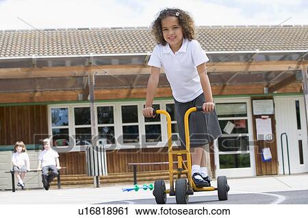 Student outside school on tricycle scooter View Large Photo Image Stock Image - Student outside school on tricycle scooter. Fotosearch